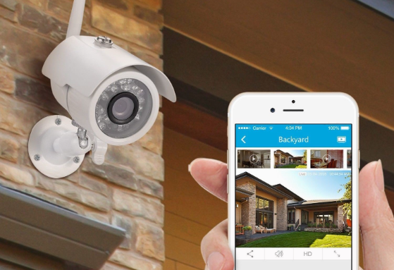 Image of outdoor security camera with mobile phone in hand.