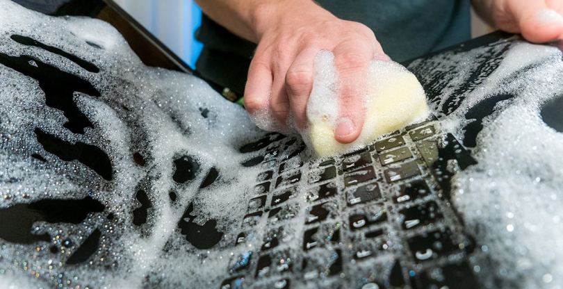 image of a laptop being cleaned with soap and water. don't do this!